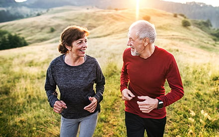 An adult couple enjoying the benefits of exercise outdoors.