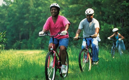 Three people biking outdoors.