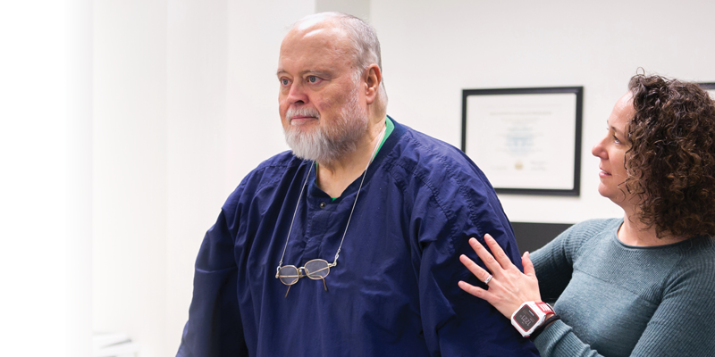 A PT assisting an older gentleman