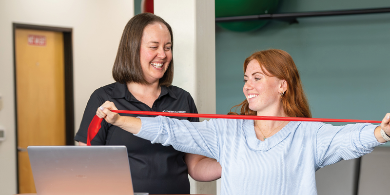 A PT and a woman with a resistance band