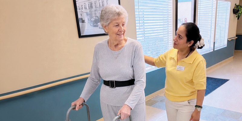 Neha Sabharwal helps a patient walk